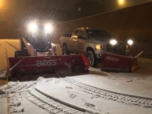 Commercial snow plow clearing snow from a parking lot in Clayton, Missouri