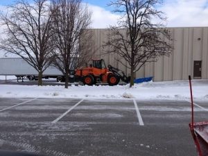 Snow removal truck plowing snow from a commercial parking lot in Webster Groves, Missouri